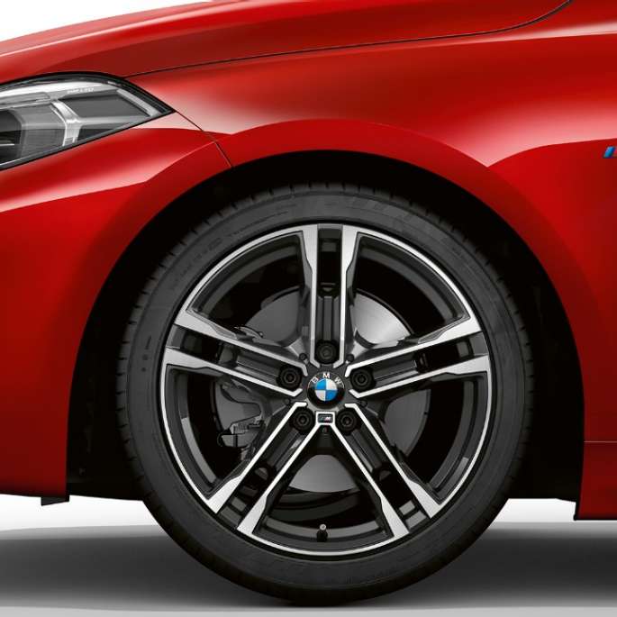 BMW Série 1, Modèle M Sport, vue de profil avant. BMW Série 1, Modèle M Sport en Melbourne Rot metallic, vue latérale avant, avec jantes BMW M 17" en alliage léger à doubles rayons 550 M, en exécution bicolore.