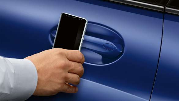 BMW Digital Key la nouvelle BMW Série 8 Coupé G15 LCI restylage 2022 BMW Digital Key la nouvelle BMW Série 8 Coupé G15 M Portimao Blau metallic LCI restylage 2022 main qui tient un smartphone devant la porte de la voiture
