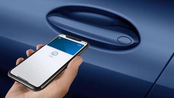 Digital Key La nouvelle BMW Série 8 Gran Coupé G16 LCI restylage 2022 tenant le smartphone devant la porte de la voiture