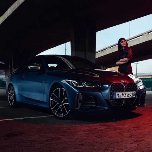 Modèle se tenant à côté de la BMW M440i xDrive Coupé G22 2020 vue de trois quarts de profil BMW M440i xDrive Coupé Arctic Race Blue metallic G22 2020 vue de trois quarts avant avec modèle