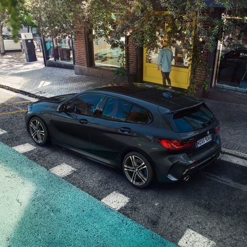 BMW M135i xDrive, en stationnement. BMW M135i xDrive en Saphirschwarz metallic, vue de trois quarts de profil en plongée, en stationnement.