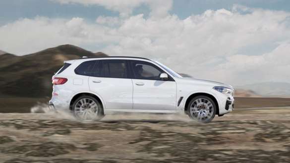 Mode de conduite xGravel, BMW X5 Mode de conduite xGravel, BMW X5 G05 2021 en Mineralweiß metallic, vue de profil, roulant sur un terrain pierreux friable