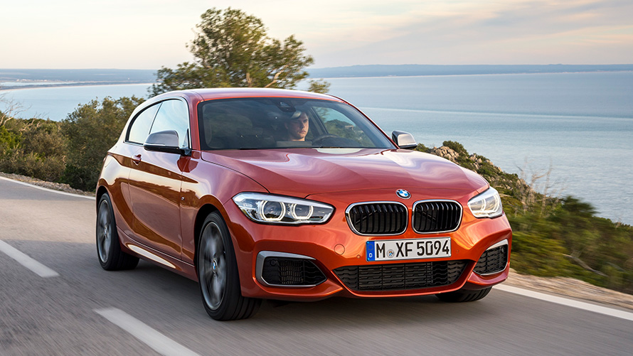 BMW M135i (F21) vue de trois quarts avant roulant devant un lac et des montagnes BMW M135i (F21) vue de trois quarts avant roulant devant un lac et des montagnes