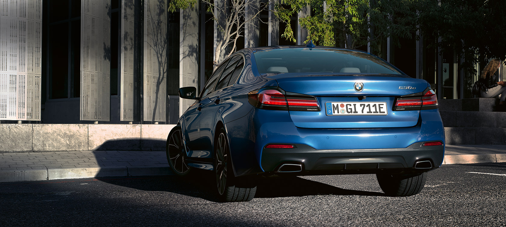 BMW Série 5 Berline eDrive (G30), Phytonicblau metallic BMW Série 5 Berline eDrive (G30), Phytonicblau metallic, vue arrière devant un bâtiment