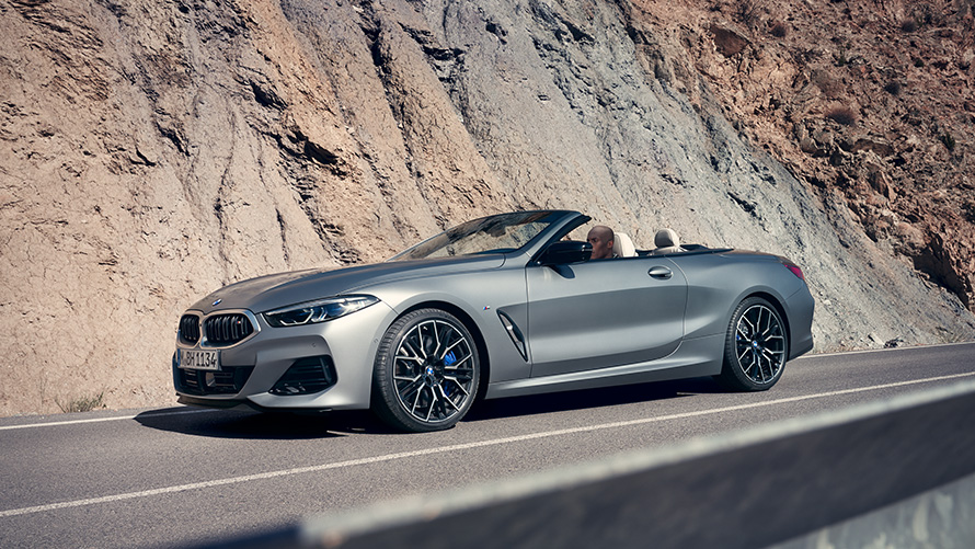 BMW Série 8 Cabrio G14 LCI Restylage 2022 avec capote ouverte en mouvement le long d’une chaîne de montagne BMW Série 8 Cabrio G14 LCI Facelift 2022 Vue de profil BMW Individual Frozen Pure Grey metallic avec capote ouverte en mouvement le long d'une chaîne de montagne