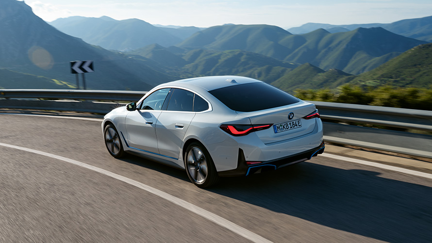 Vue de trois quarts arrière de la BMW i4 eDrive40 G26 2021 en mouvement BMW i4 eDrive40 G26 2021 Mineralweiß, vue de trois quarts arrière en mouvement