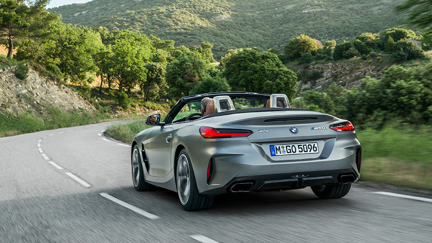 La BMW Z4 M40i G29 en mouvement sur une route de campagne BMW Z4 Roadster M40i G29 2019 BMW Individual Frozen Grey metallic en mouvement sur une route de campagne, vue de trois quarts arrière