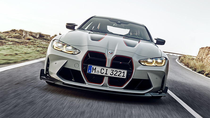 BMW M4 CSL G82 teinte spéciale BMW Individual Frozen Brooklyn Grey metallic, barreaux des naseaux en noir avec film signature en Rot, vue avant en mouvement sur la route