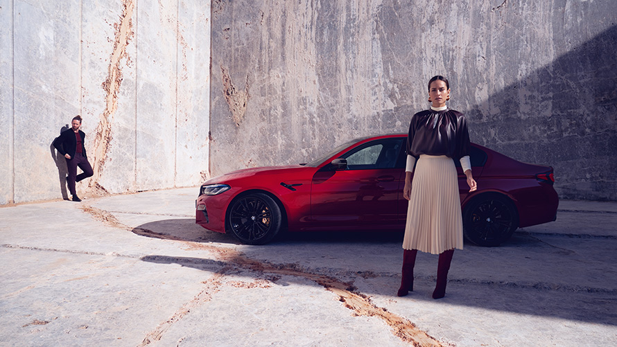 BMW M5 F90 LCI restylage 2020 vue de profil avec femme BMW M5 F90 LCI restylage 2020 BMW Individual Imola Rot vue de profil avec femme