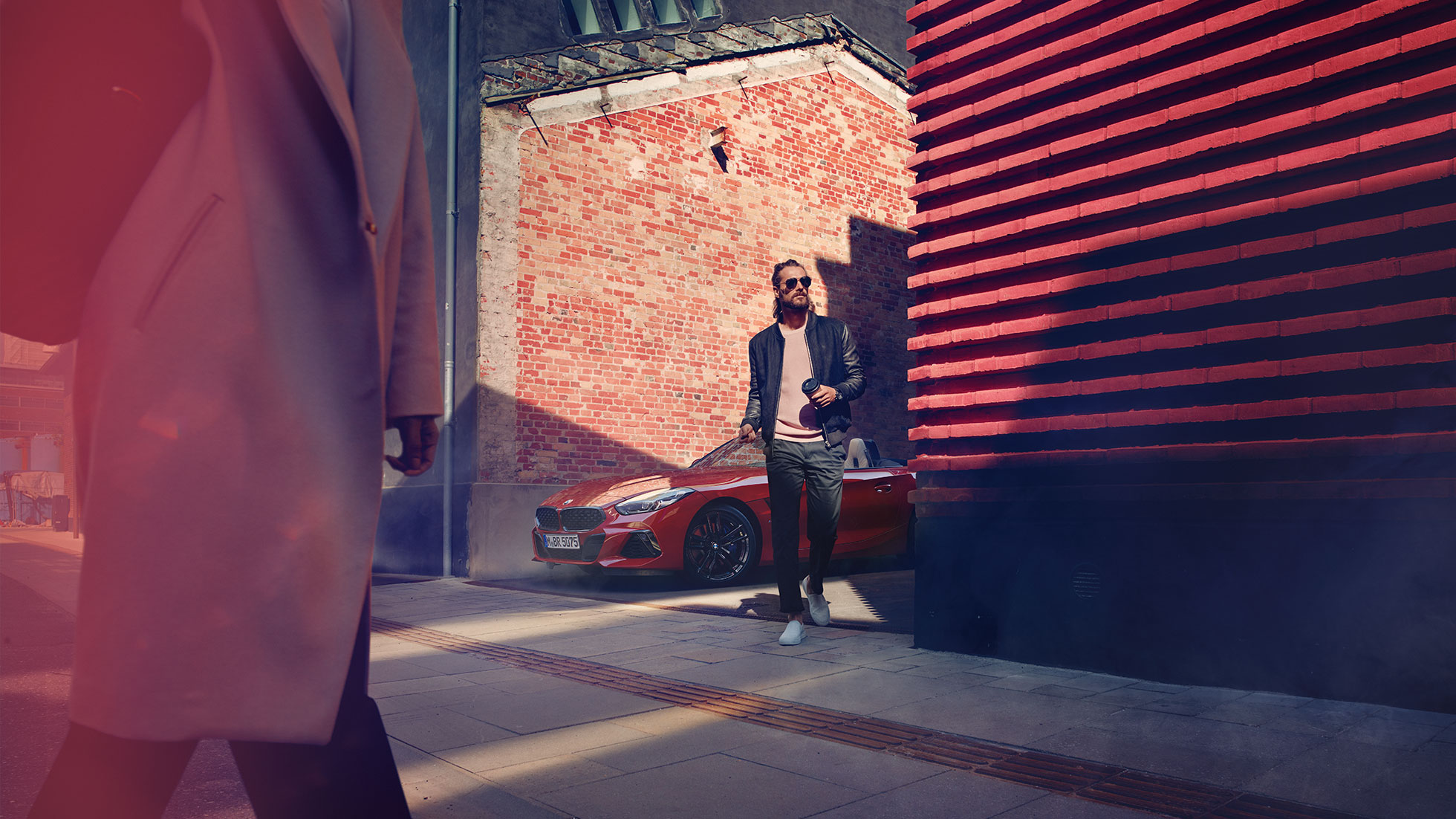 La BMW Z4 Roadster dans une rue latérale Homme dans une rue latérale devant la BMW Z4 Roadster